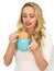 Young Woman Dunking a Biscuit in a Mug of Tea