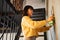 Young Woman Dusting Apartment