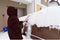 young woman dusting snow off a car during blizzard