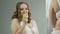 Young woman eating apple, satisfied with her body reflection in underwear