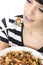 Young Woman Eating A Bowl of Colourful Vegetarian Tomato Pasta