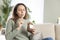 Young woman eating chocolate from a jar at home