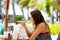 Young woman, eating desert in a restaurant on beach summer resort