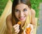 Young woman eating dried apricots in the park. Healthy food concept