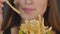 Young woman eating french fries close detail