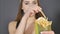 Young woman eating french fries close detail