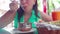 A young woman is eating an Indian meat dish in a tropical cafe.