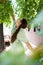 Young woman eating mulberry pluck it from tree.