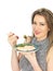 Young Woman Eating Poached Salmon and Salad