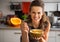 Young woman eating pumpkin soup in kitchen