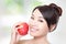 Young woman eating red apple with health teeth