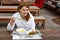 Young woman eating soup and salad in outdoor restaurant.