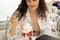 Young woman eating strawberry ice cream while sitting in an outdoor cafe