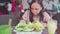 A young woman is eating a very hot Indian dish in a tropical cafe.