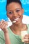 Young Woman Eating Yoghurt In Studio