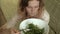 Young woman eats greens salad.