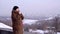 Young woman on the edge of the mountain looking over the city