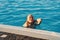 a young woman emerging from the pool. rest and entertainment in the water.