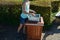 Young woman emptying a trash can in the park. it is her job or a summer job in a municipal gardening company serving citizens. hol