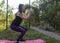 A young woman is engaged in exercises. Woman on a yoga mat outdoors. Girl prefers a healthy lifestyle