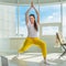 A young woman is engaged in fitness in the morning. Online sports activity. Yoga in the morning