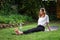 A young woman is engaged in fitness in nature on a rug.