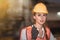 Young woman engineer with walkie talkie on blurred factory background