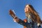 Young woman enjoy playing guitar. Blue sky background