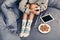 Young woman enjoying cozy time with tablet in bed