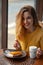 Young woman enjoying a cup of coffee and a slice of delicious ca