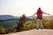 Young woman enjoying in nature with arms spread at viewpoint in mountain. positive energy, nature, concept