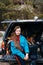 Young woman enjoying nature while sitting in the car trunk