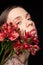 Young woman enjoying softness of fresh flowers