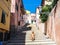 Young woman enjoying the sun in an alley of a small rural medieval village