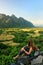 Young woman enjoying the view of farm fields in Vang Vieng, Laos