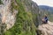 Young woman enjoying the view of Inca Bridge and cliff path near