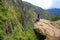 Young woman enjoying the view of Inca Bridge and cliff path near