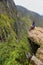 Young woman enjoying the view of Inca Bridge and cliff path near