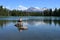 Young woman enjoying view of Sisters volcanoes reflected in Scott Lake, Oregon.