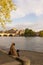 A young woman enjoys working on her computer sitting on the banks of the Seine in Paris, by a spring sun