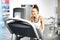 A young woman in an exercise room is running on an automatic treadmill.