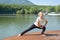 Young woman is exercising on the pier at the lake. active sports lifestyle. outdoor gymnastics.