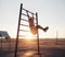 Young woman exercising on wall bars with her legs up