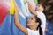 young woman exerting effort on indoor climbing wall