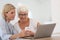 Young woman explaining to elderly woman how to use smartphone