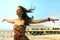 Young woman eyes closed arms wide open at beach