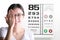 Young woman on eyesight test chart background. Eyesight and eye