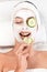 Young woman with face mask and cucumber