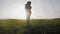 Young woman farmer in hat holding orange pumpkin in her hands the at field at sunset time. Pumpkin harvest. Agriculture