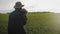 Young woman farmer in hat holding orange pumpkin in her hands the at field at sunset time . Pumpkin harvest. Agriculture